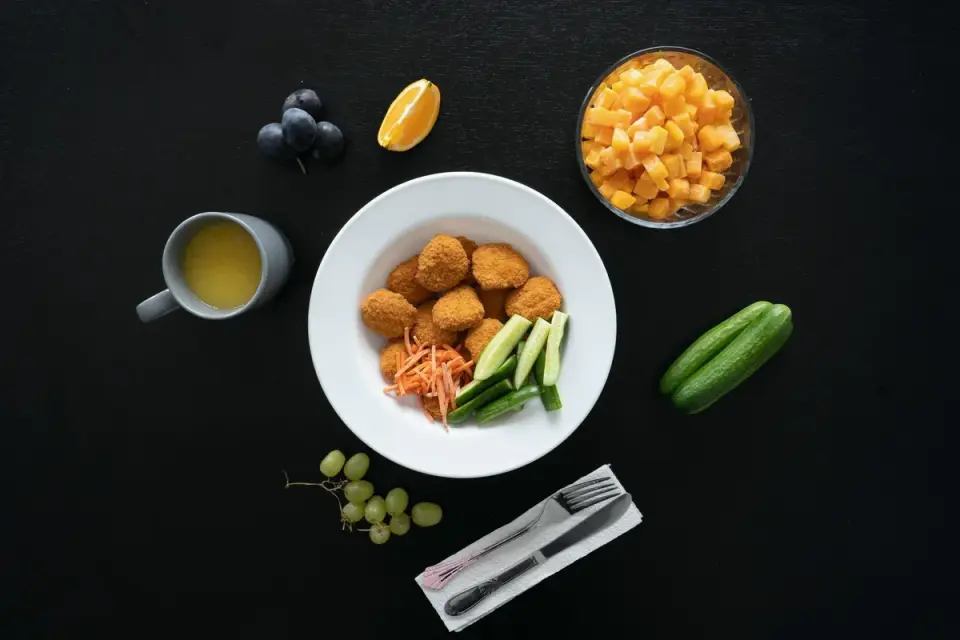A dog bowl containing small, evenly cubed pieces of fruit