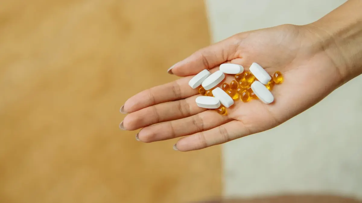 A dog owner holding a pill and a probiotic capsule side by side before mealtime