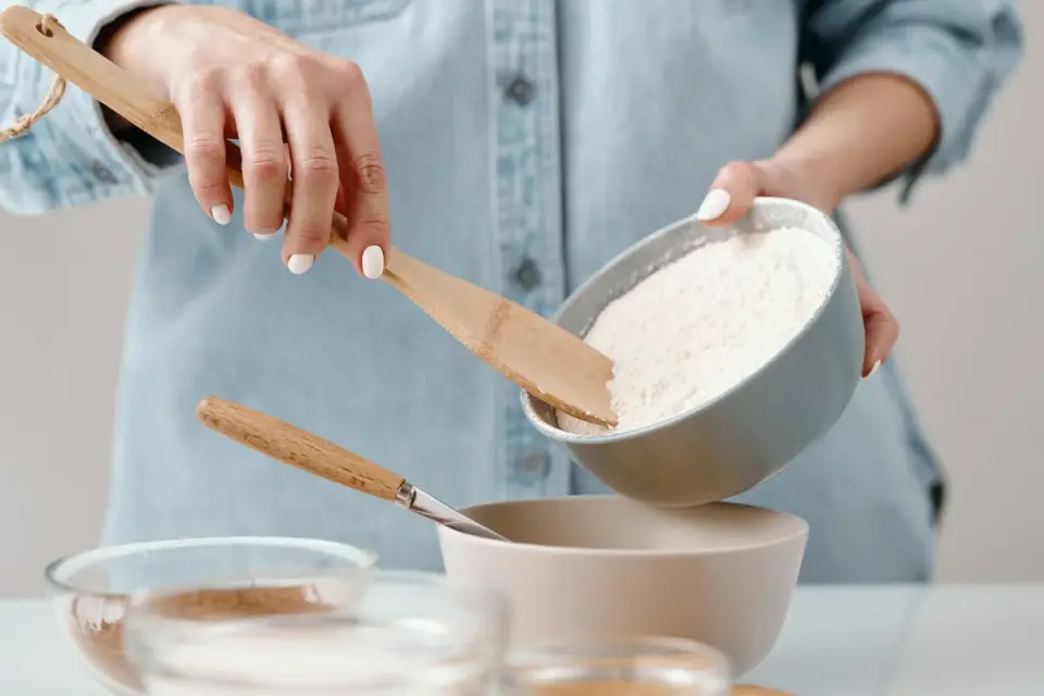 A person blending old and new dog kibble together in a bowl