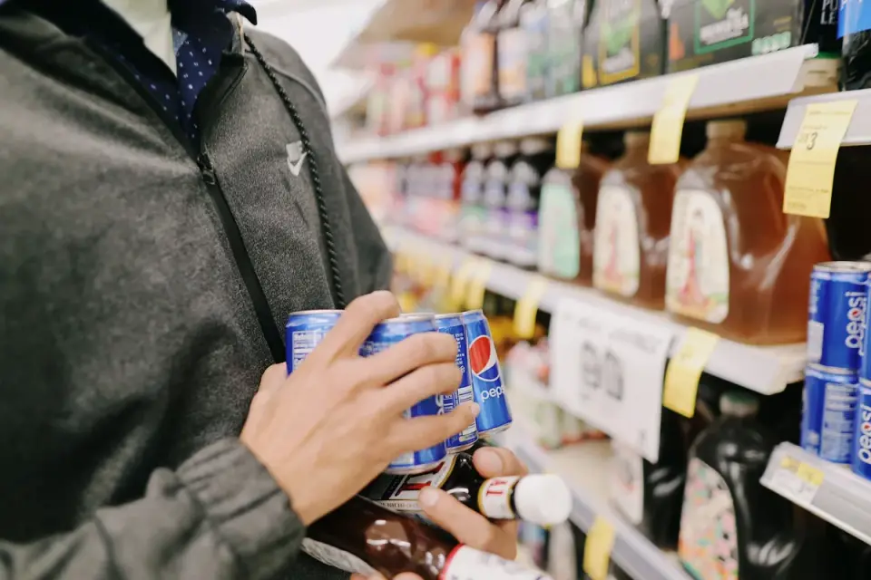 A pet owner reading the ingredient panel on a dog supplement bag in a store aisle