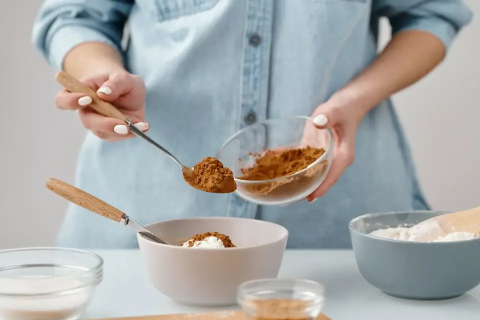 A veterinarian adding a measured scoop of powder to a dog&#x27;s food bowl