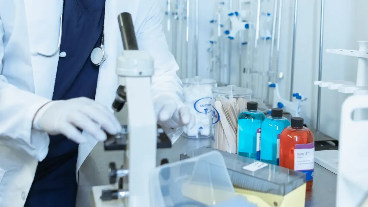 A veterinarian in an exam room checking a probiotic supplement label against a dog's chart