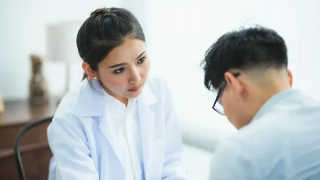 A veterinarian reviewing a dog supplement label at a clinic counter with an owner and their dog