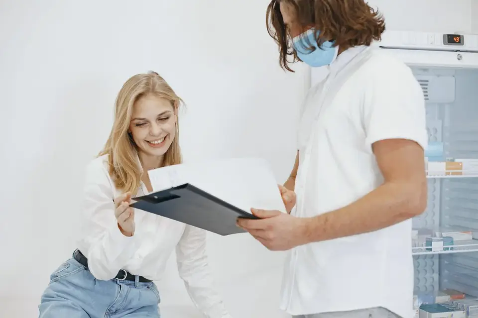 A veterinarian reviewing a health chart with a dog owner in an exam room