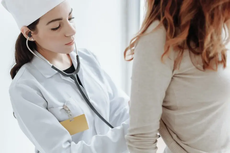 A veterinarian using a stethoscope to listen to a dog&#x27;s abdomen