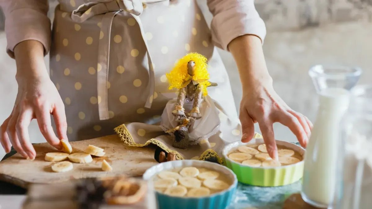 Peeled banana sliced into rounds on a wooden cutting board next to a dog's food bowl